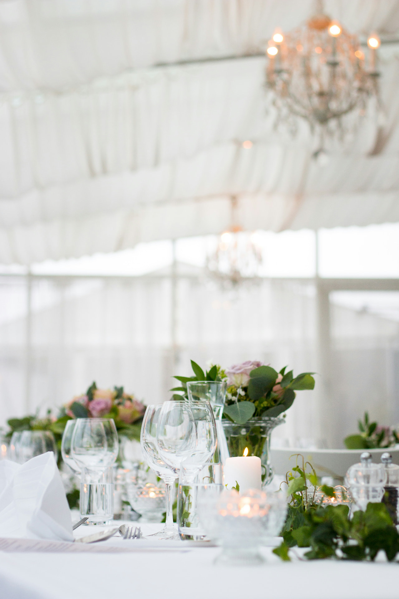 Elegant white marquee table setting with chandeliers