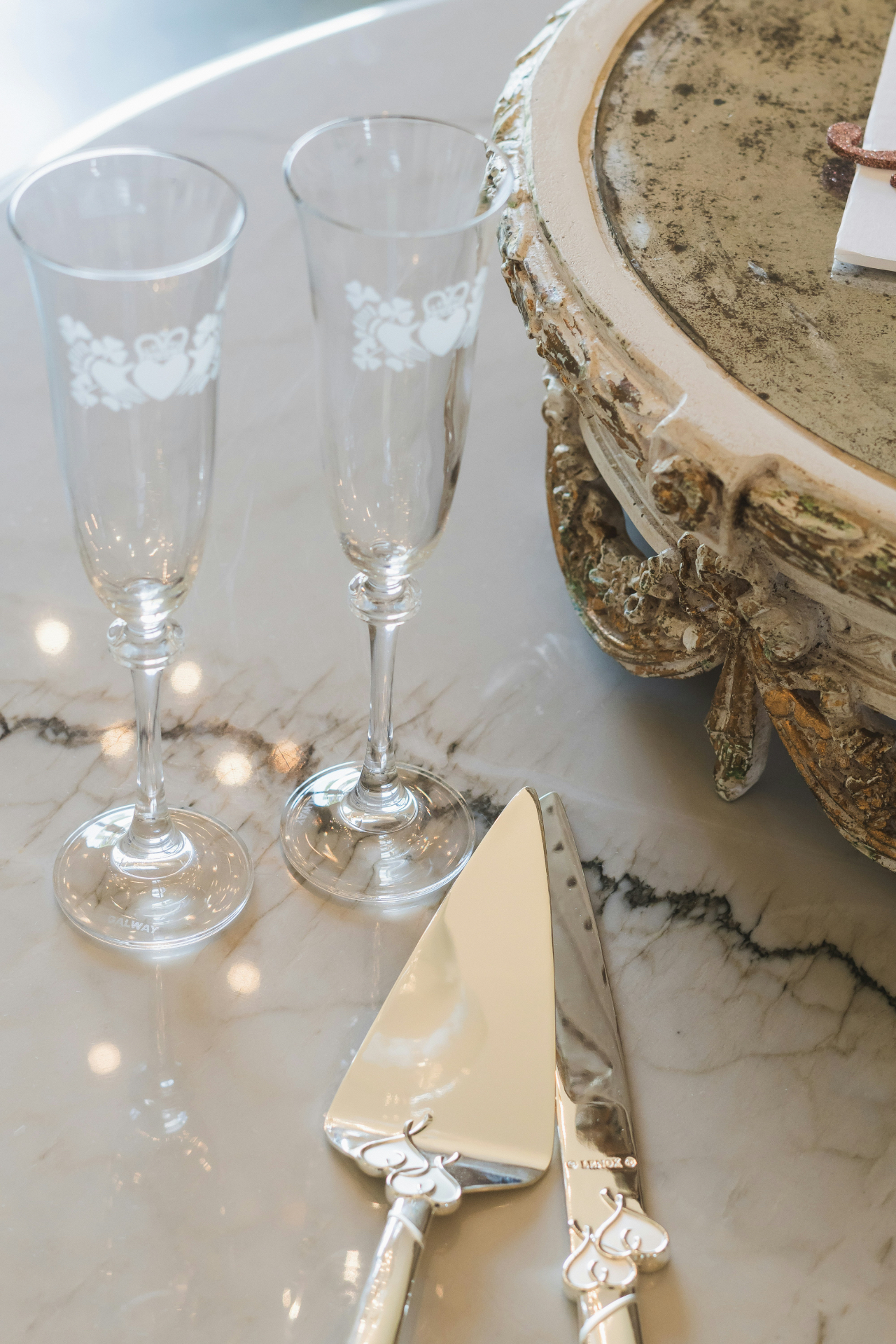 Champagne flutes and cake server on a marble table