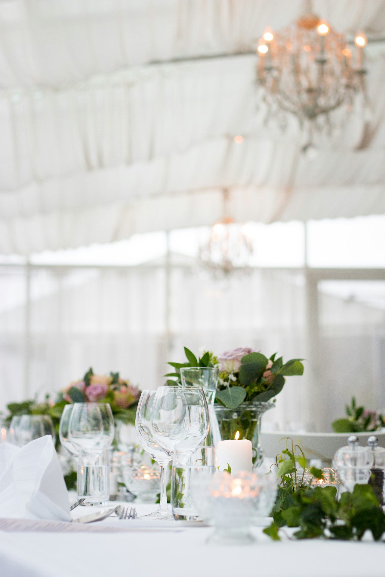 Elegant white marquee table setting with chandeliers